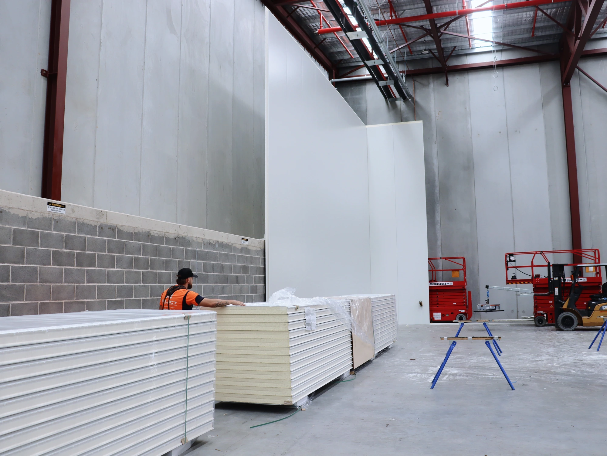 Installer at the panel stacks beside the first standing wall of the Chullora cool room