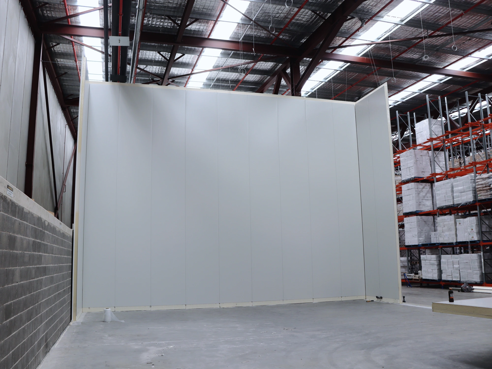 Full height insulated panel walls at Chullora, with the client's stocked pallet racking right alongside