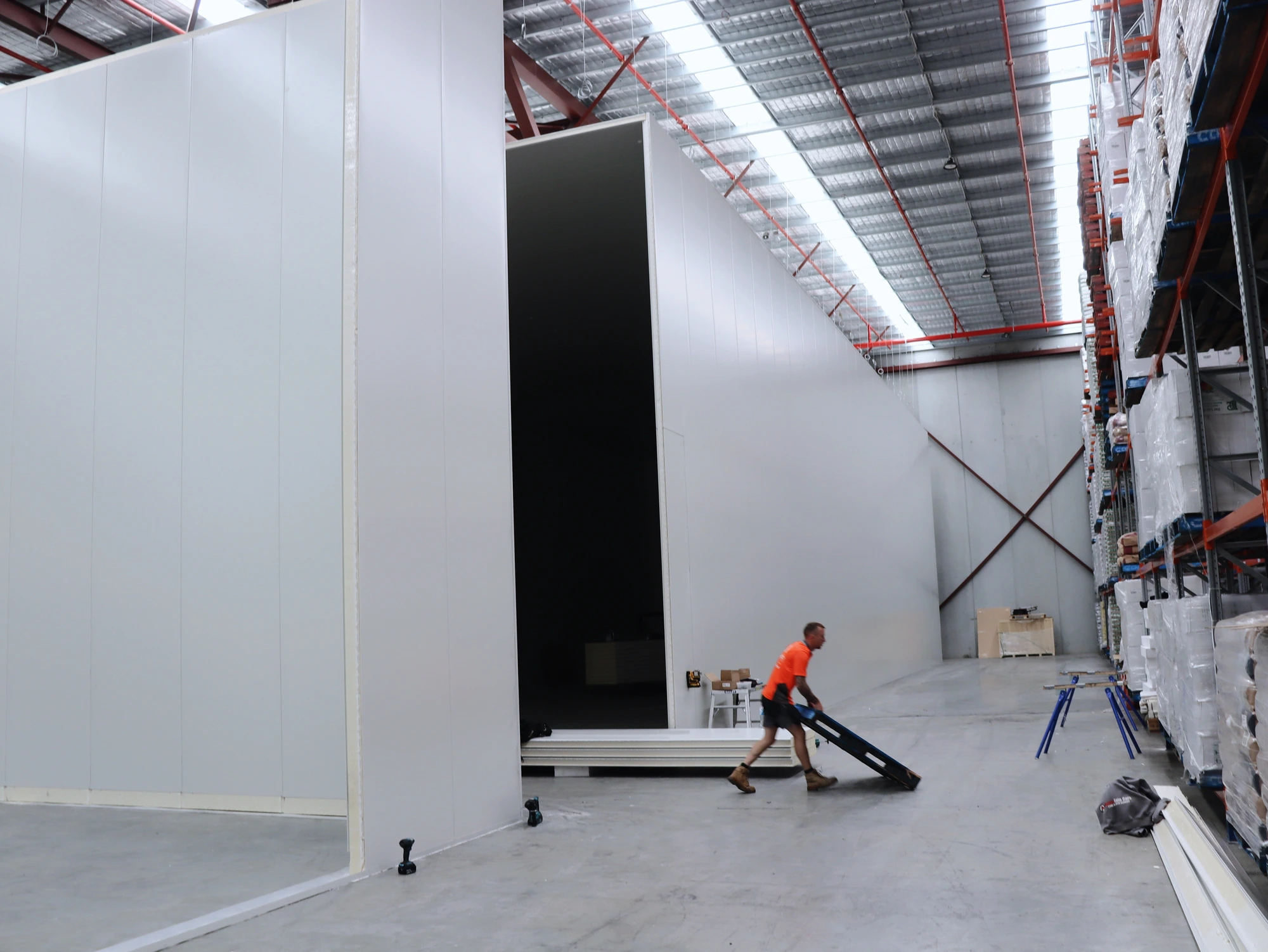 The tall door opening left in the Chullora cool room wall, with the warehouse racking beyond