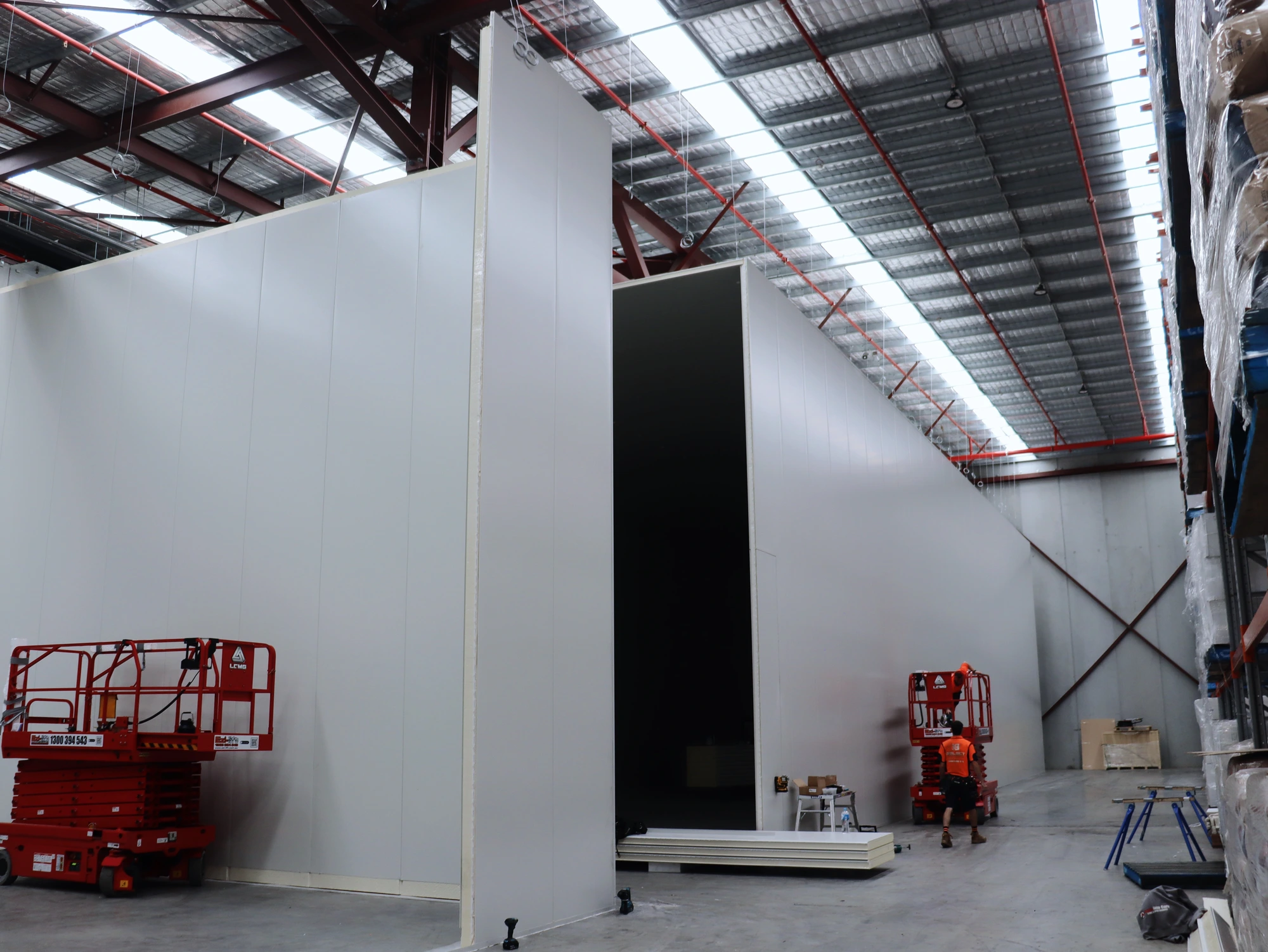 Full height insulated panel walls and the main door opening at Chullora, scissor lifts standing by