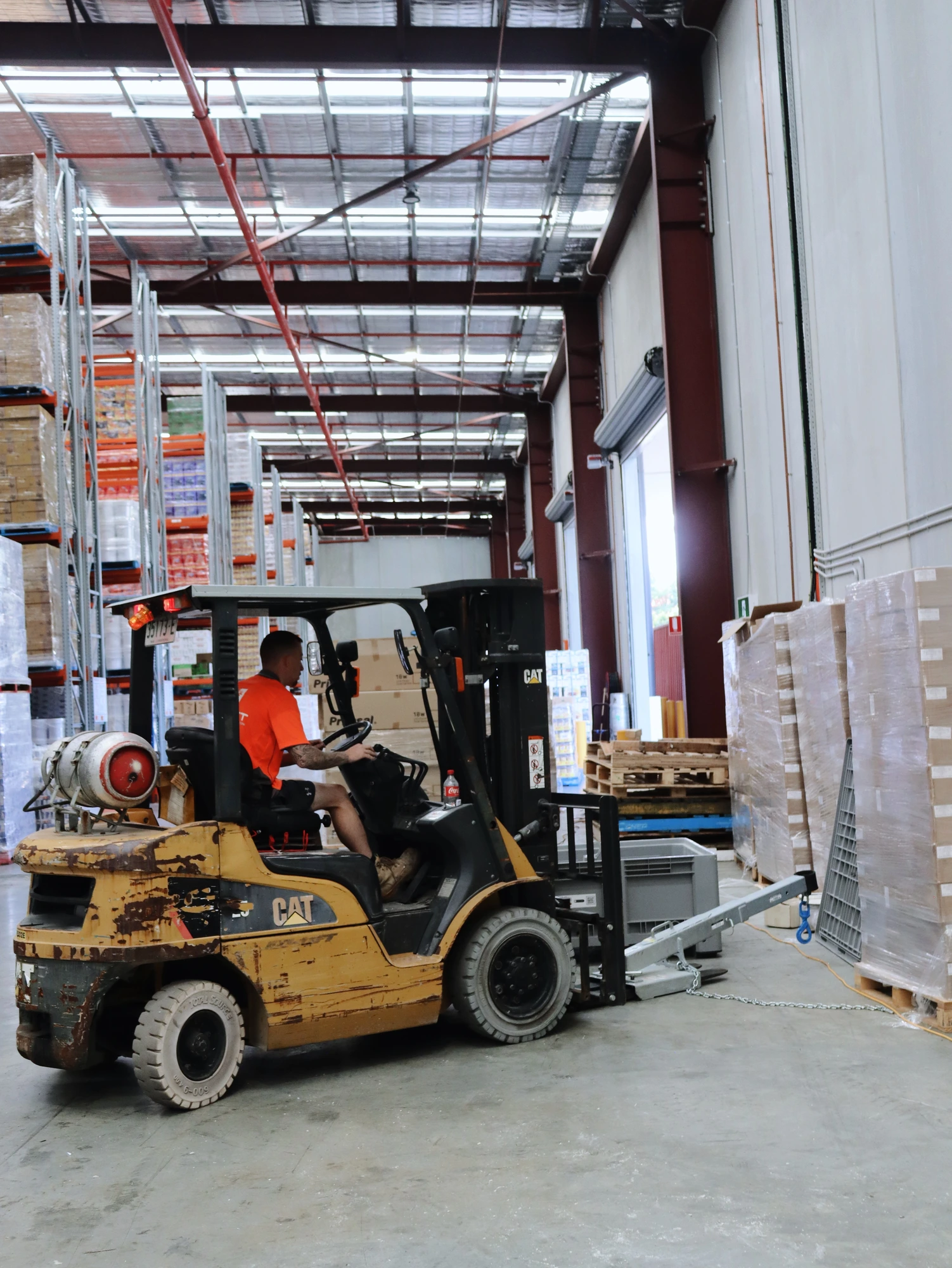 The client's forklift working the Chullora warehouse aisle while the cool room build goes on around it