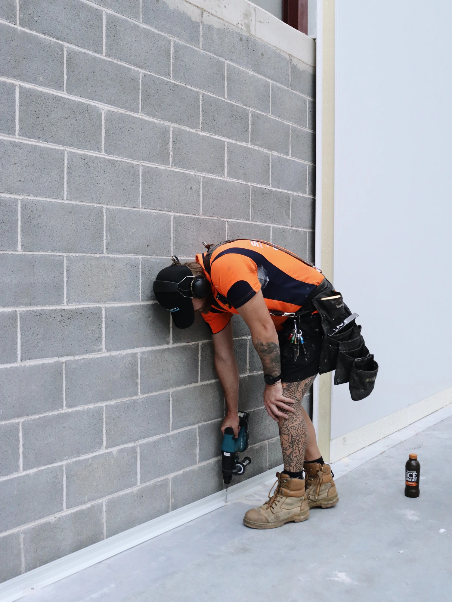 Fixing the base angle to the warehouse slab at Chullora, the detail that keeps the wall line true